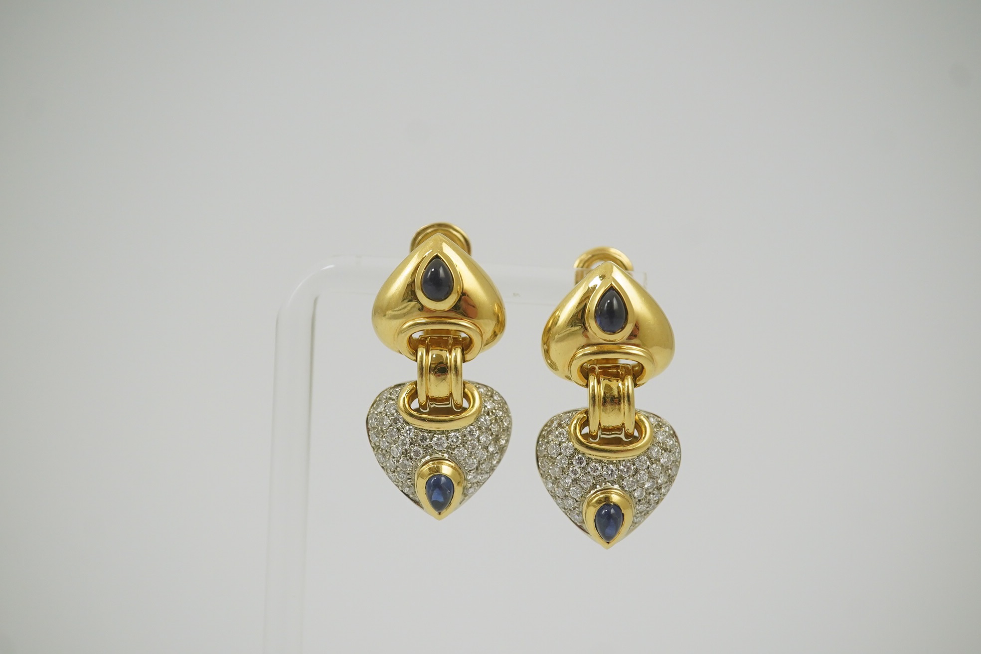 A modern pair of Mappin & Webb 18ct gold, cabochon sapphire and diamond cluster set stylised heart shaped drop earrings